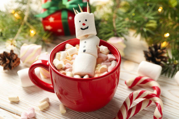istock Cup with snowman marshmallow on Christmas wooden background 1292541194