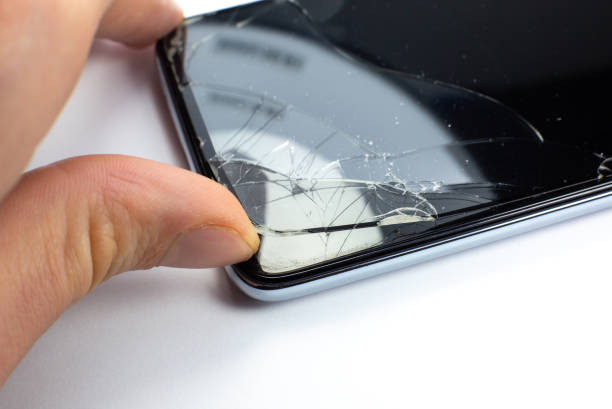 istock Man replacing the broken tempered glass screen protector for smartphone. Close up. 1292541359