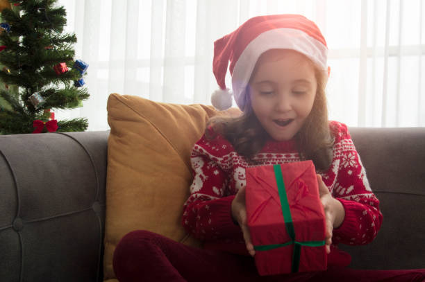 istock Happy smiling child girl with Christmas present 1292541438