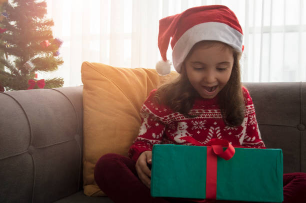 istock Happy smiling child girl with Christmas present 1292542428