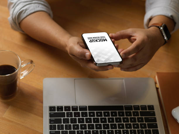 istock Businessman using smartphone on worktable with laptop in home office room 1292542884