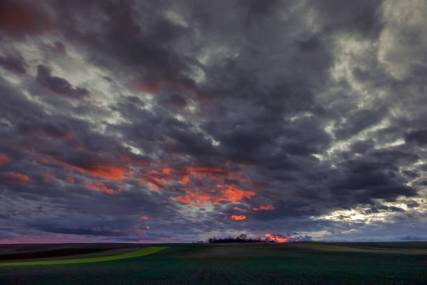 istock red dark clouds on the sky with green fields 1292544358