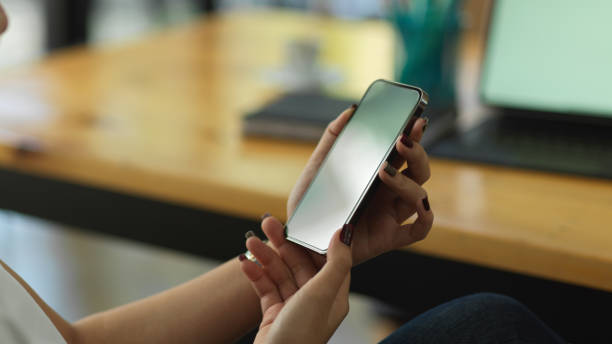 istock Female hands holding smartphone in blurred background 1292545004