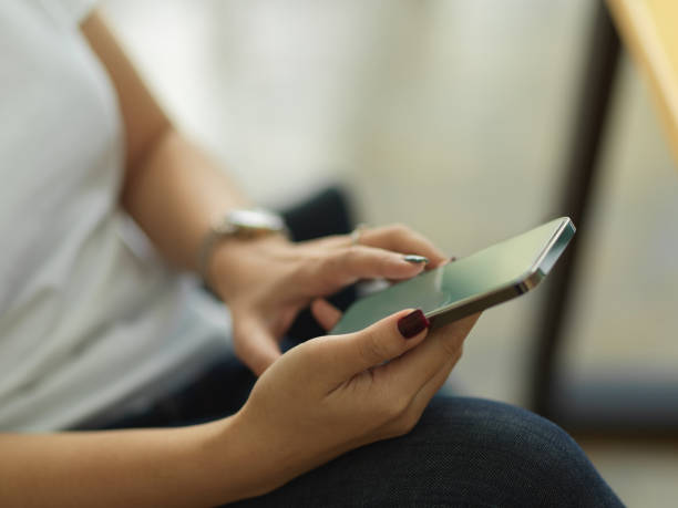 istock Female hands using smartphone while sitting in home office room 1292545007