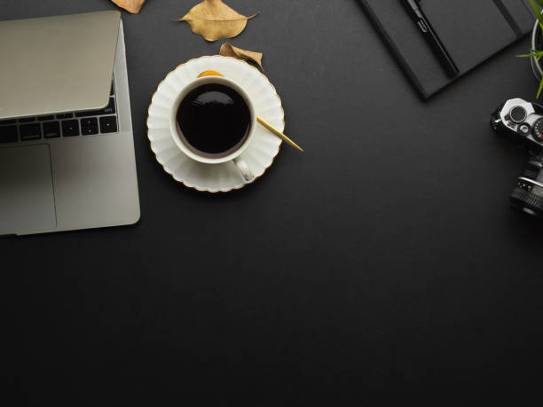 istock Top view of worktable with laptop, coffee cup, supplies and copy space 1292545041