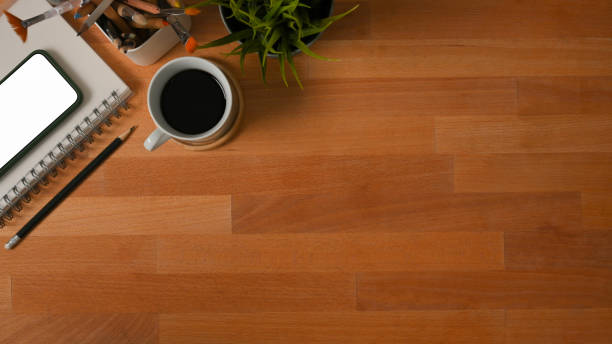 istock Wooden table with copy space, coffee cup, stationery and plant pot 1292545046