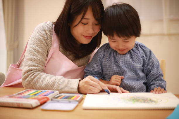 istock Image of a boy and a nursery teacher drawing 1292545507