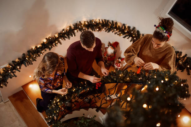 vrienden versieren trappen voor nieuwjaar partij - christmas tree stockfoto's en -beelden