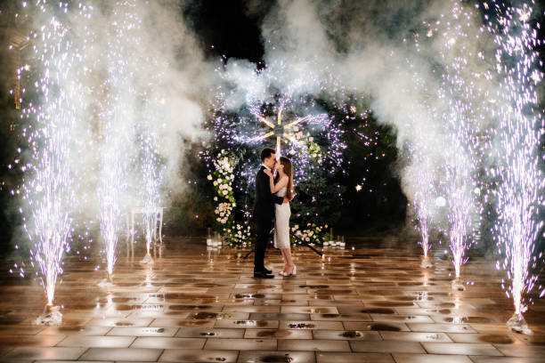 жених и невеста стоят в коридоре фонтанов фейерверков - dancing fountains стоковые фото и изображения