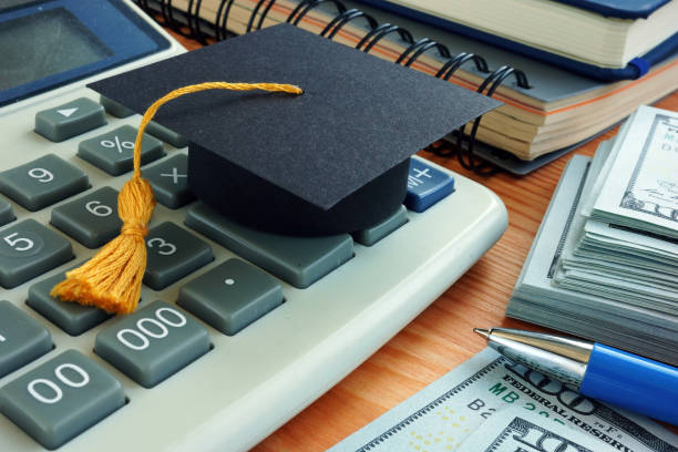 istock Student loan concept. Graduation cap on calculator. 1292546490