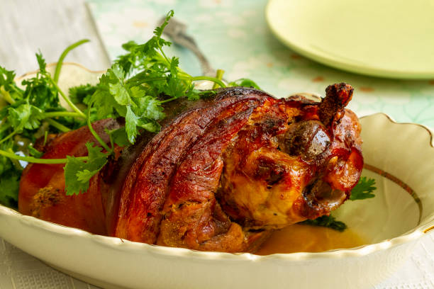 istock A hot, golden roasted pork knuckle with fresh grass on a dish stands on a table. 1292547374