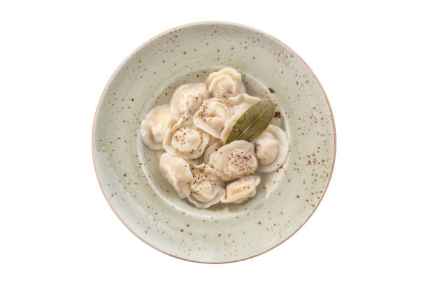 Russian meat dumplings pelmeni on grey plate isolated on white background Russian meat dumplings pelmeni on grey plate isolated on white background top view russian pelmeni stock pictures, royalty-free photos & images
