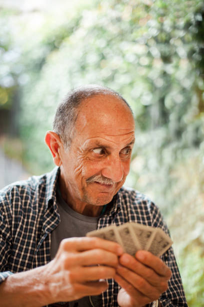 istock Grandfather's Funny look while playing cards. 1292549760