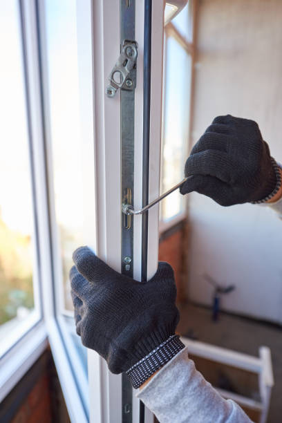 istock Close-up of a worker's hands adjusts a new plastic window. 1292552748