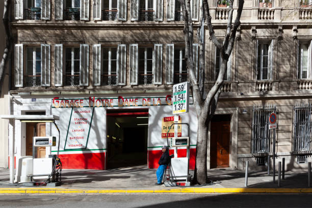 gas station attendant waiting at his small station for customers in Marseilles, France in summer heat Marseille, France - April 1, 2015: gas station attendant waiting at his small station for customers in Marseilles, France in summer heat. marseille station stock pictures, royalty-free photos & images