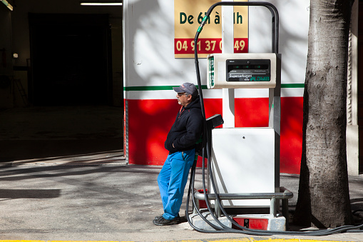 Marseille, France - April 1, 2015: gas station attendant waiting at his small station for customers in Marseilles, France in summer heat.