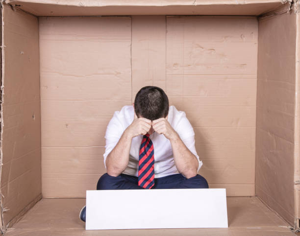 istock devastated unemployed businessman sitting in cardboard box, no job, copy space 1292555150