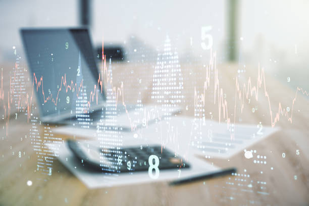 istock Abstract virtual financial graph hologram on blurry calculator and computer background, financial and trading concept. Multiexposure 1292556161