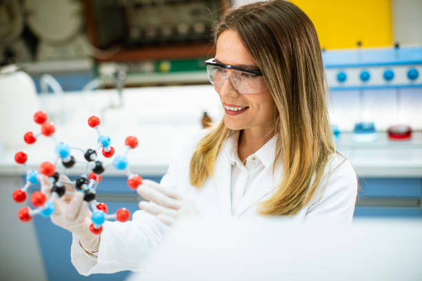 istock Female chemist hold molecular model in the lab 1292557491