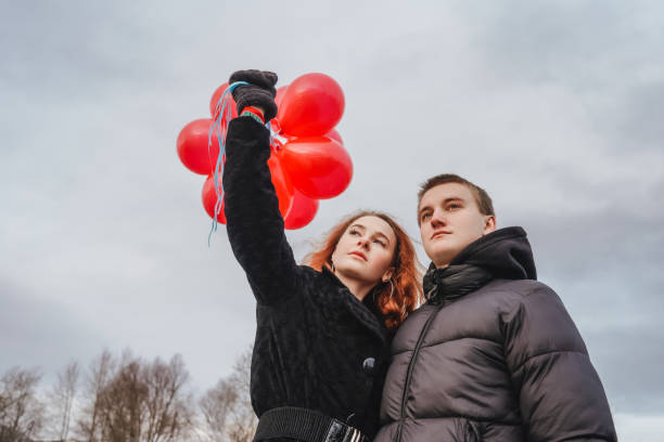 istock Love couple with red balloons outdoor 1292557521