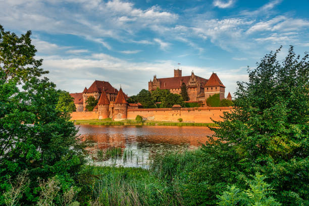 medieval malbork castle, poland Malbork, Poland - 27.07.2020:Brick gothic Malbork castle on the river Nogat, Poland. Under the walls of the castle is a medieval encampment lovers of the Middle Ages malbork photos stock pictures, royalty-free photos & images