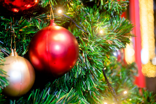 istock Balls on christmas tree, bokeh lights and holly wreath. 1292560654