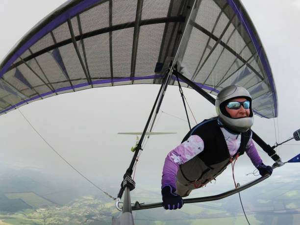 Hang glider pilot on high altitude under the cloud Hang glider pilot on high altitude under the cloud glider hang glider hanging sky stock pictures, royalty-free photos & images