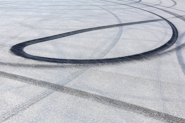 istock Black burnt rubber drift traces made by cars on asphalt 1292562401