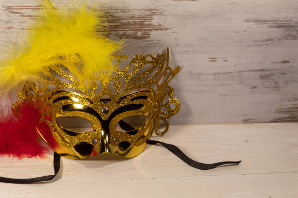 istock golden carnival mask with a yellow and red feather 1292563183