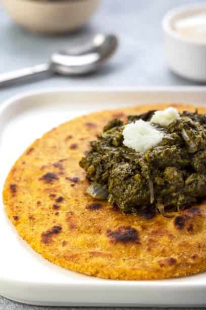 visão de perto de pães de fubá e folhas de mostarda curry, famosa comida indiana especialmente preparada nos invernos, makki ki roti - sarson ka saag - specially - fotografias e filmes do acervo