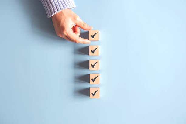 istock Wood cube with check mark on blue background, Checklist concept, Copy space. 1292563799