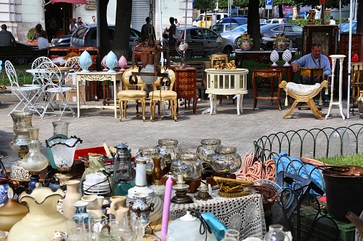 Typical merchandise at a flea market stall in Paris, France: dishware, candleholders, jewel boxes and decorative figures