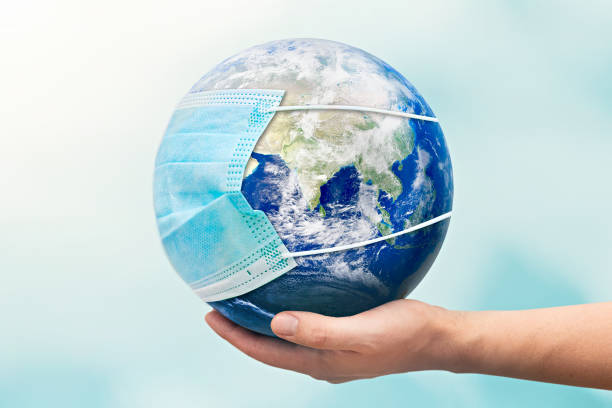 istock Hand holding Earth globe with face mask 1292569140