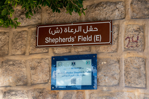 Jerusalem, Israel, December 28, 2018 : A plate with the inscription Shepherd’s Field in English and Arabic on the wall of the Greek Monastery - Shepherds Field in Bayt Sahour in Palestine