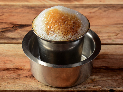 Traditional Indian, Madras filter coffee in a steel cup also known as tumbler and dabarah, south indian style, selective focus