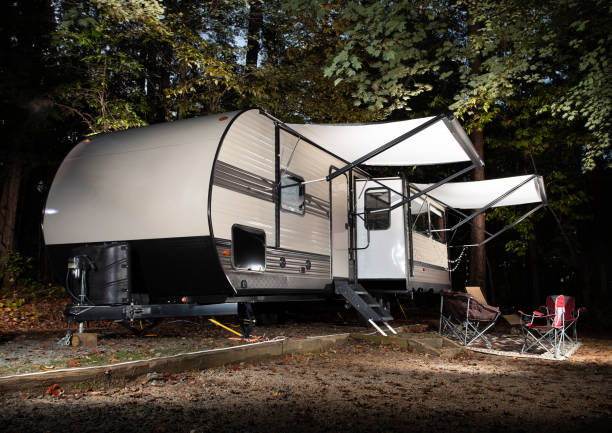 istock Camping trailer with slide out and awning out at a campsite 1292571509