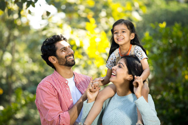feliz madre con el padre llevando a su hija en el hombro en el parque - subcontinente indio fotografías e imágenes de stock