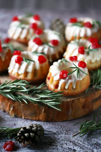 istock Christmas cakes with white icing, red berries and rosemary. 1292574218