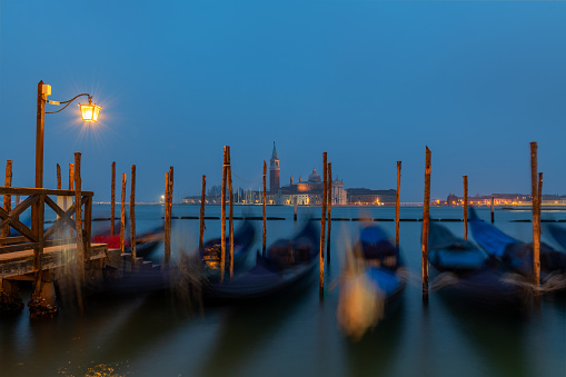Venedig bei Nacht mit Gondeln im Vordergrund und klassischer Laterne