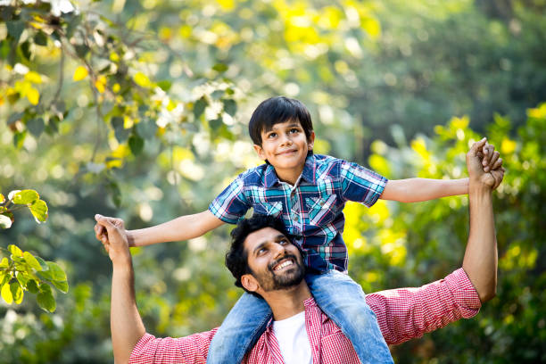istock Father carrying son on shoulder at park 1292574492