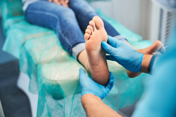 unrecognized chiropodist on blue gloves examining toes and feet of female patient in medical center - podiatrist podiatry pedicure chiropodist imagens e fotografias de stock