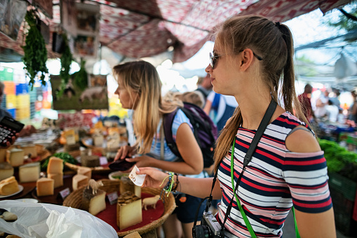 Mother and daughter buying cheese at the Spanish farmer's market.  \nNikon D850
