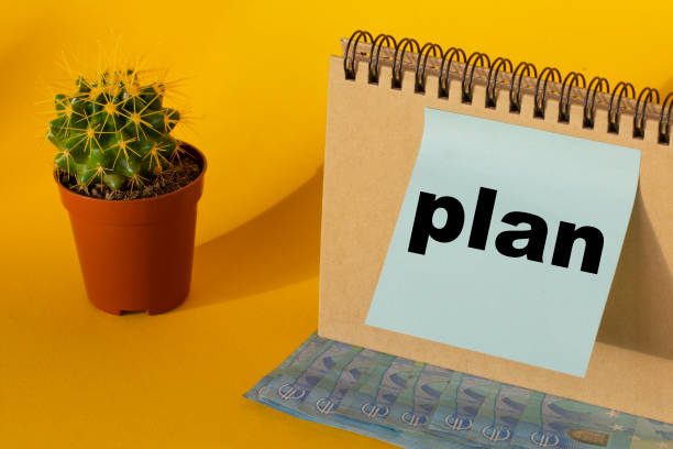 istock the word plan on a blue sticker and euro banknotes on a yellow background 1292575403