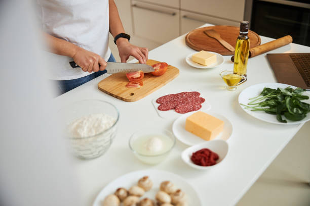 istock Slicing tomato while getting all the ingredients ready for the pizza 1292575454