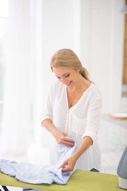 istock Joyful woman looking at clean shirt. 1292575866
