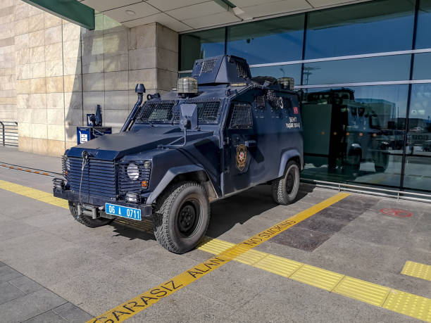 carro blindado da polícia na rua perto do terminal do aeroporto de ankara esenboga. moderno porta-aviões blindado no fundo da parede de vidro do edifício - blue security system security staff land vehicle - fotografias e filmes do acervo