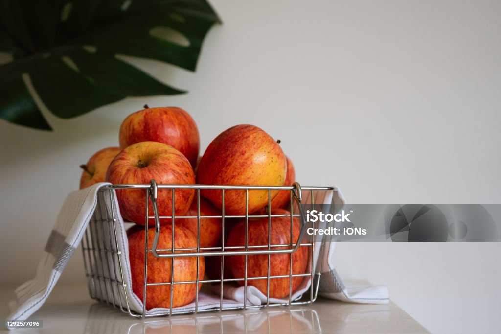 Apples on wire basket Bunch of gala apples in wire basket on white background with copy space Wire Basket Stock Photo