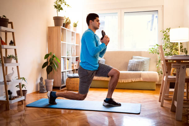 young man working out split squats with kettlebell at home - kettle bell activity aerobics athlete imagens e fotografias de stock