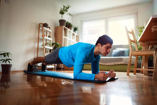 istock Home workout, young man doing plank in his apartment 1292577216