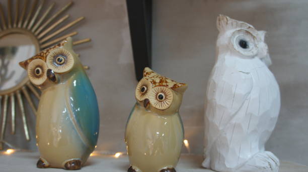 istock Three ceramic owls on a shelf, decorative souvenir 1292578120